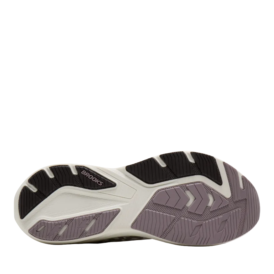 A close-up of a Brooks running shoe's outsole, showing a color-blocked design in black, off-white, and muted lavender-gray.