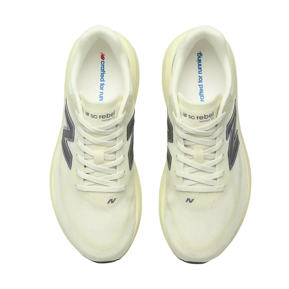 A pair of New Balance shoes in a light pistachio green colourway, viewed from directly above. The shoes feature silver 'N' logos and laces, with the New Balance 'N' branding visible on the sides and the 'New balance' logo on the tongues.